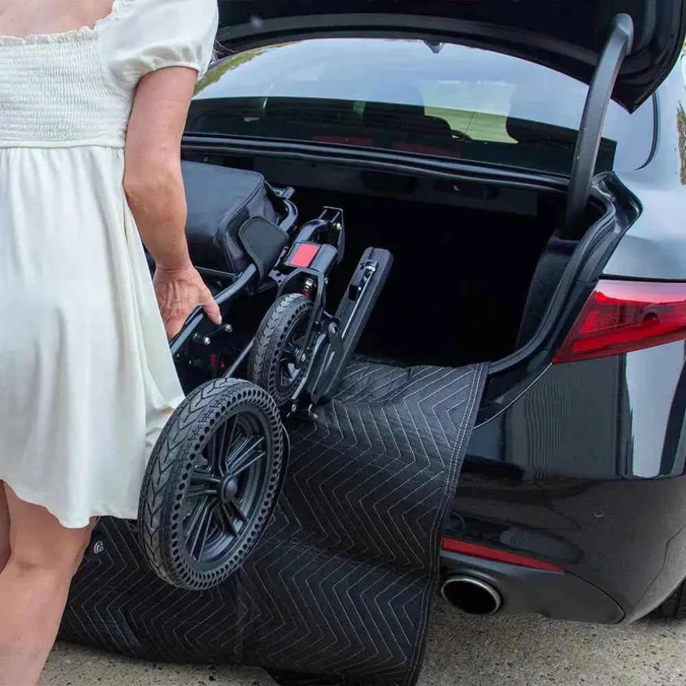 Woman using the Travel Buggy bumper blanket to protect her car's paint while loading a folding power wheelchair.